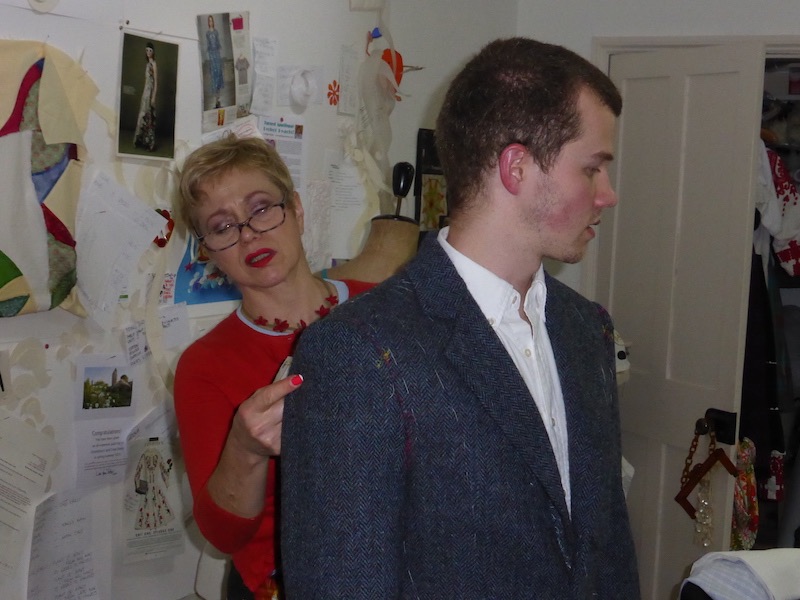 Philippa working on fitting a garment on her son