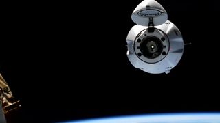 a white cone-shaped spacecraft capsule on a black background above a small blue-white arc of earth visible below