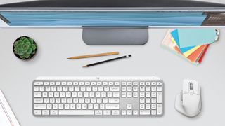 Lysegrå Logitech MX Keys S og Logitech MX Anywhere 3S med hvid arbejdsstation
