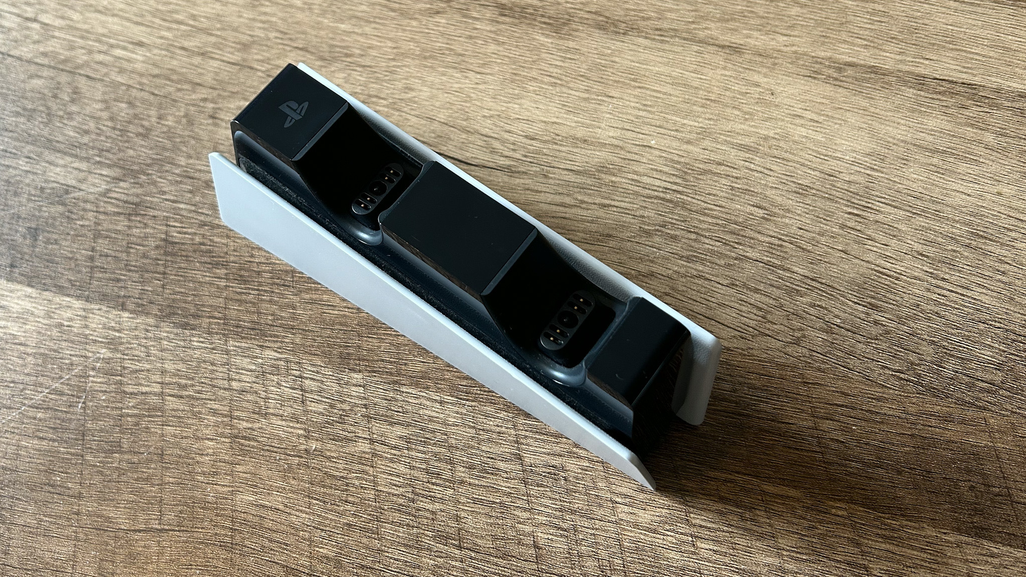 DualSense charging station top down on a wooden table