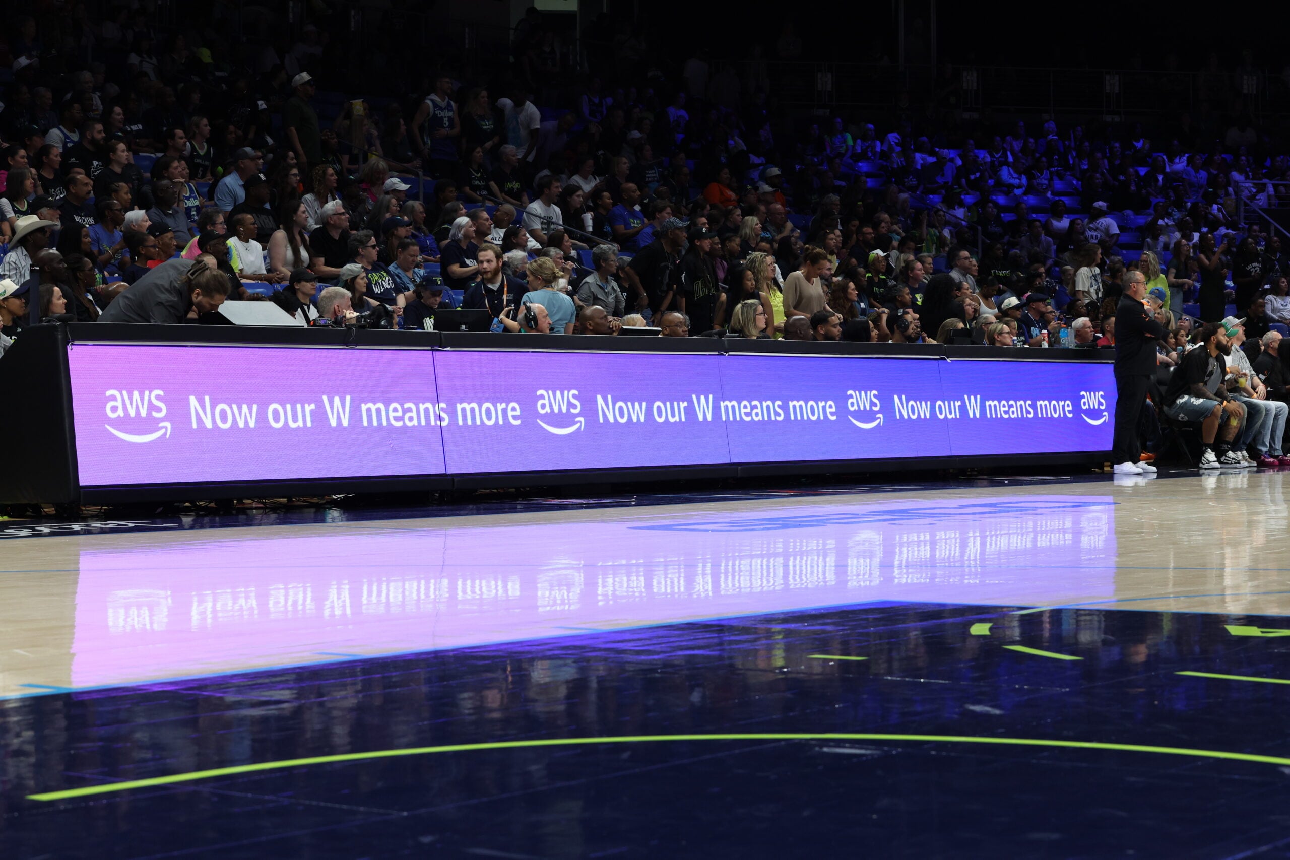 Image of AWS Now our W means more display at basketball game. AWS Logo.