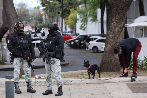 National Guards patrol a sidewalk outside of the General Prosecutor's headquarters in Mexico City, Sunday, Feb. 22, 2026, after the death of the leader of the Jalisco New Generation Cartel, Nemesio Rubén Oseguera Cervantes, known as "El Mencho." (AP Photo/Ginette Riquelme)