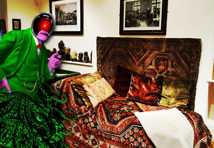 Sigmund Freud's study with his famous couch. Behind the couch stands an altered version of the classic Freud portrait in which he is smoking a cigar. Freud's clothes and cigar have all been tinted in bright neon colors. His head has been replaced with the glaring red eye of HAL9000 from Kubrick's '2001: A Space Odyssey.' His legs have been replaced with a tangle of tentacles