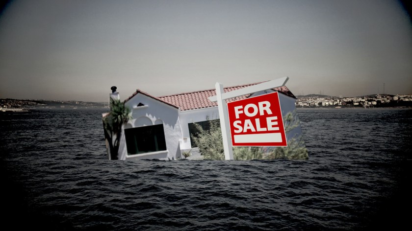 A Spanish Mission-style bungalow with a FOR SALE sign out front; it is sinking into a dark and stormy ocean.