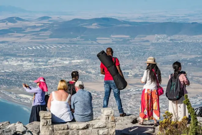 Des touristes photographient la vue depuis le sommet de la montagne de la Table, située au Cap, en Afrique du Sud.