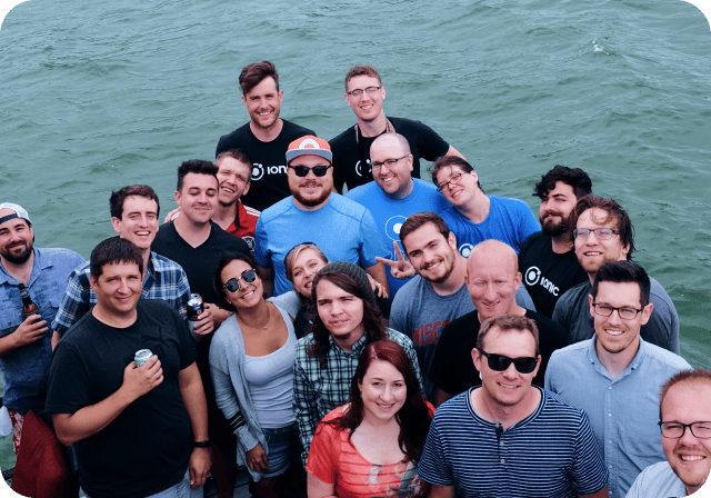 Ionic team gathered in triangle formation next to water