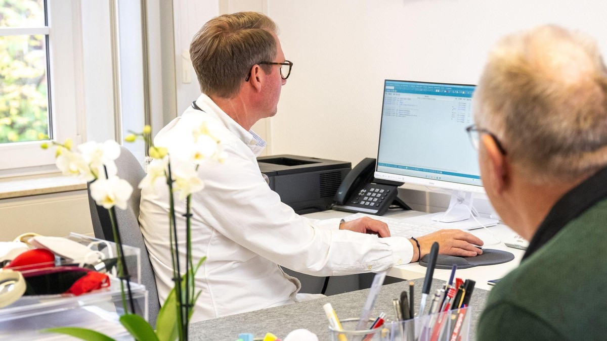 Weniger Papier, mehr digital: Das Bundesgesundheitsministerium hat einen umfassenden Plan zum Bürokratieabbau im Gesundheitswesen vorgelegt. Ein Arzt schaut vor einem Patieten in einen Computer