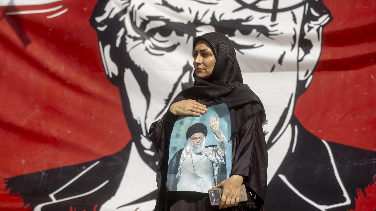 TEHRAN, IRAN - JULY 5: A woman holds a portrait of Iran's slain Supreme Leader, Ayatollah Ali Khamenei, in front of a large banner depicting U.S. President Donald Trump with a target on his head, during Khamenei's funeral ceremonies at the Grand Mosalla on July 5, 2026 in Tehran, Iran. Khamenei and members of his family were killed on February 28 during U.S.-Israeli strikes at the beginning of the war, bringing an end to his 36-year rule over Iran. A multi-city state funeral will be held over six days before his body is laid to rest on July 9, in his hometown of Mashhad, Iran. (Photo by Majid Saeedi/Getty Images) Iran Holds Dayslong Funeral For Late Ayatollah Ali Khamenei