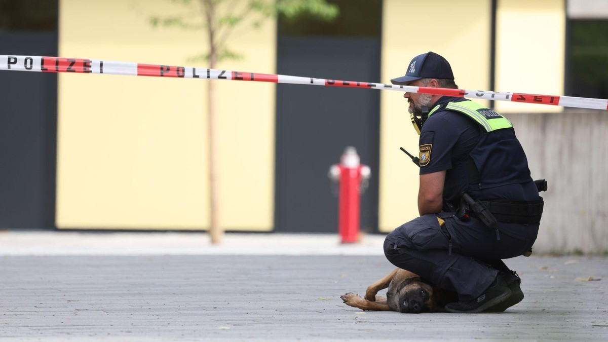 Ein Polizist mit Hund hockt vor dem Welfen-Gymnasium. Nach einem Vorfall mit mehreren Verletzten und einer Festnahme an dem Gymnasium in Oberbayern deutet laut einem Polizeisprecher vieles auf eine Amoklage hin. (zu dpa: «Hinweise auf extremistisches Motiv nach Angriff in Schongau») Festnahme und Verletzte an Gymnasium in Schongau