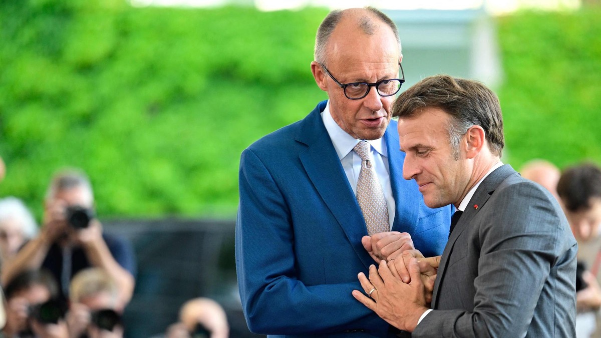 German Chancellor Friedrich Merz (L) welcomes France's President Emmanuel Macron as he arrives for a meeting with state leaders of the European Group of Five (E5) and the NATO Secretary General on June 24, 2026 at the Chancellery in Berlin, Germany. (Photo by John MACDOUGALL / AFP) Merz und Macron schütteln sich erfreut die Hände