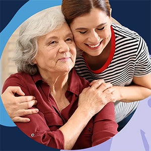 Older adult and woman hugging