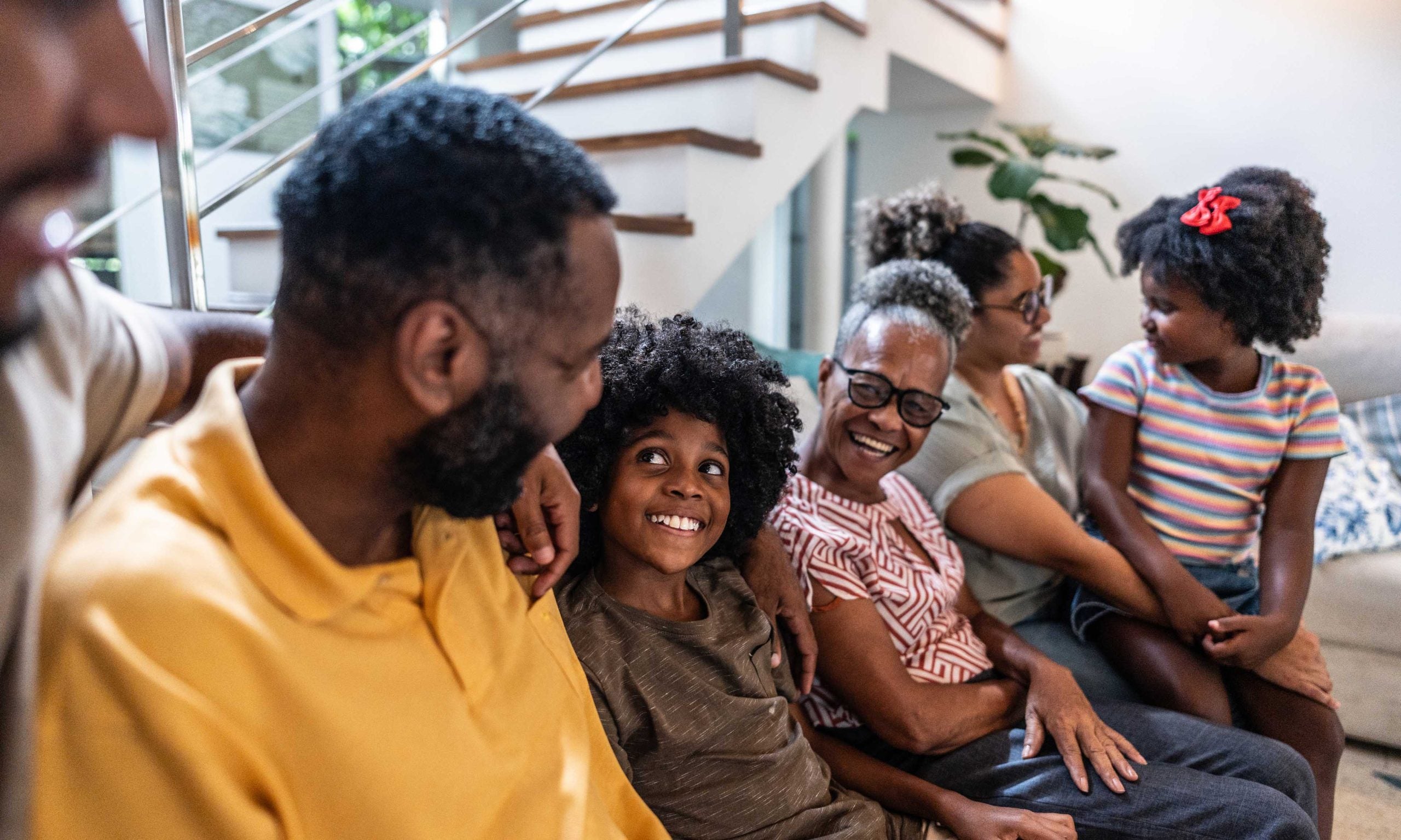Family sitting together on the couch including dad, mom, brother and sister
