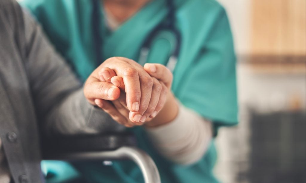Caretaker helping patient.