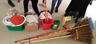 Mops, brooms, and cleaning chemicals in bottles and bags