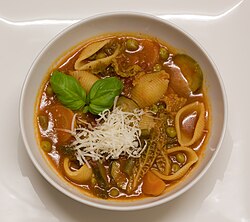 plate of brightly multi-coloured vegetable soup, with pasta