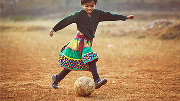 A child plays soccer in a field.
