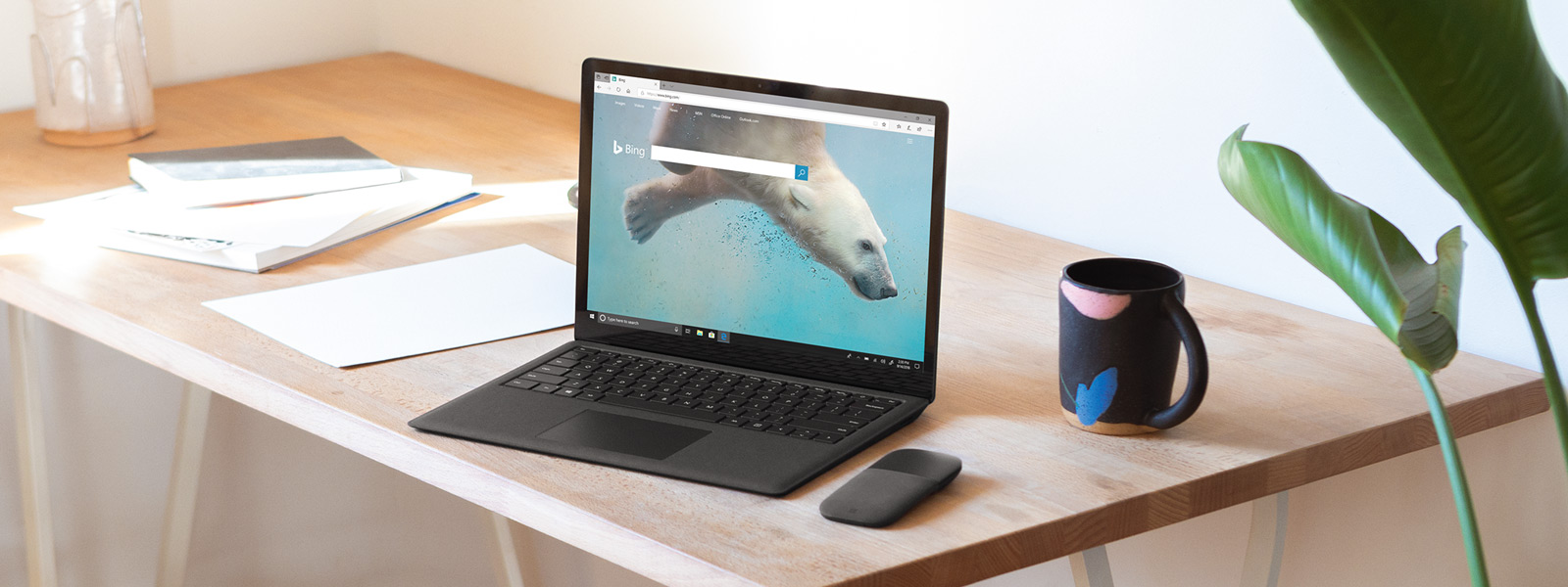 Surface Laptop computer on a desk, showing a Bing webpage in a Microsoft Edge browser