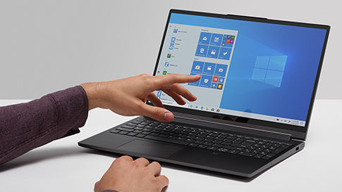 Hand pointing to start screen of Windows 10 laptop