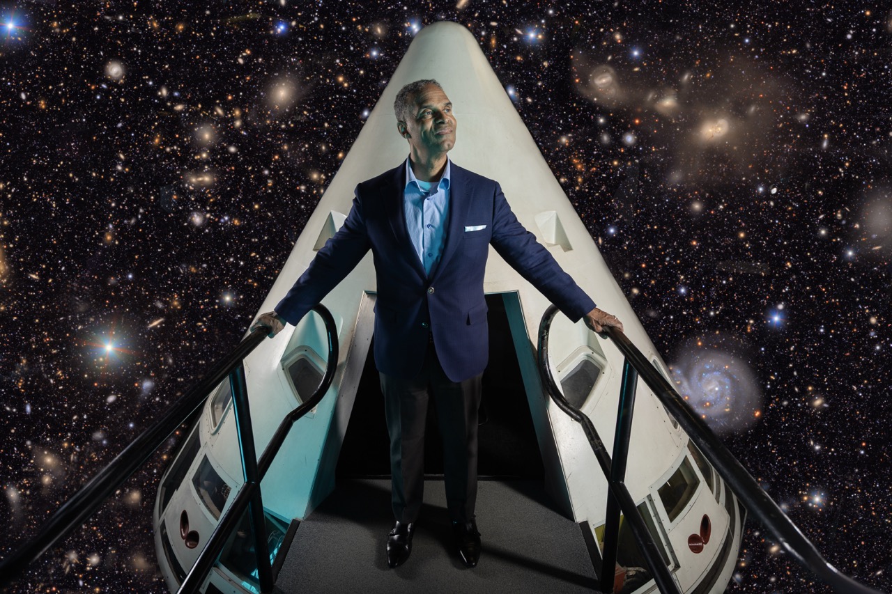 Provost Alec Gallimore standing in a spacecraft-style setting with a galaxy background.