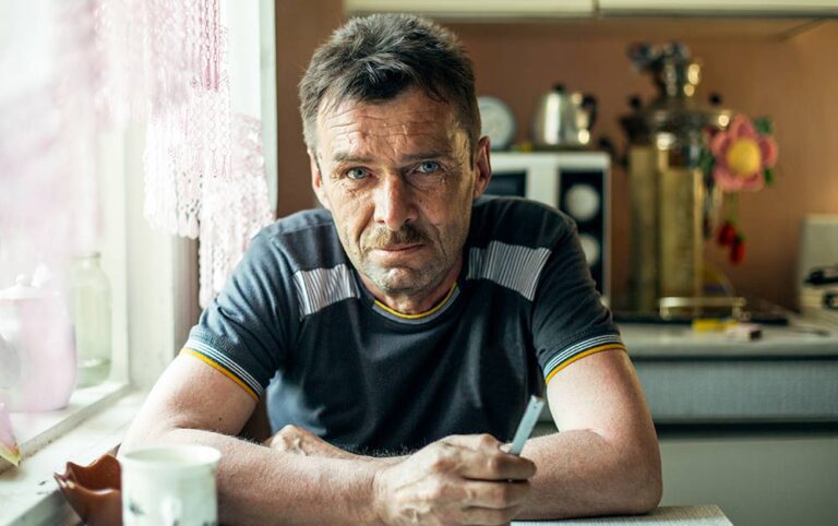 Distraught man at kitchen table.